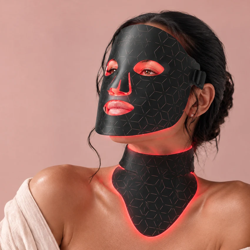 Una mujer con el Auren Pro puesto: la máscara en el rostro y la pieza que cubre el cuello y baja hasta el escote, las dos encendidas en luz roja.