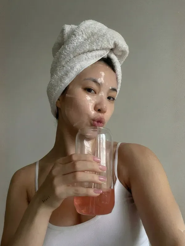 Mujer con el cabello envuelto en una toalla y la mascarilla Bio Collagen puesta.
